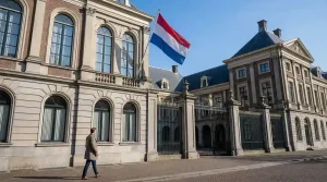 Officieel gebouw met Nederlandse vlag en een open poort die toegang symboliseert